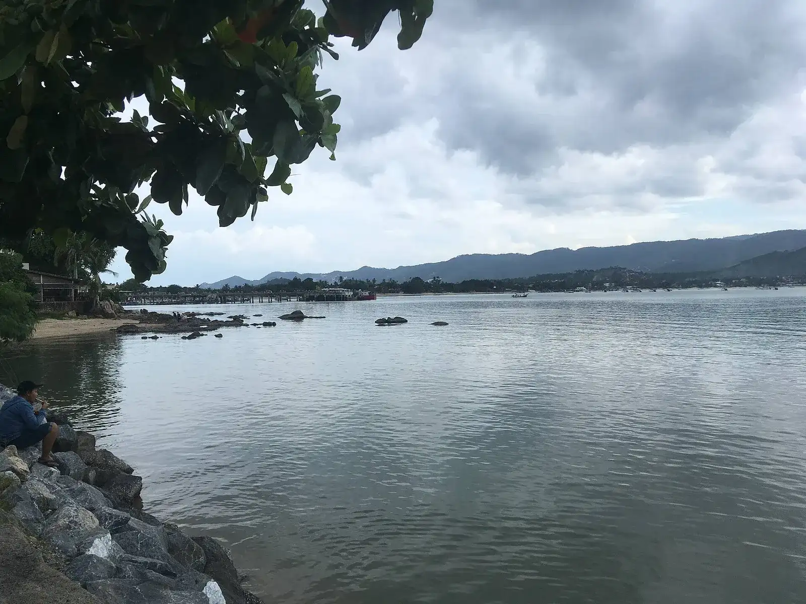 Bang Rak Bay on Koh Samui under cloudy skies, viewed from the rocks