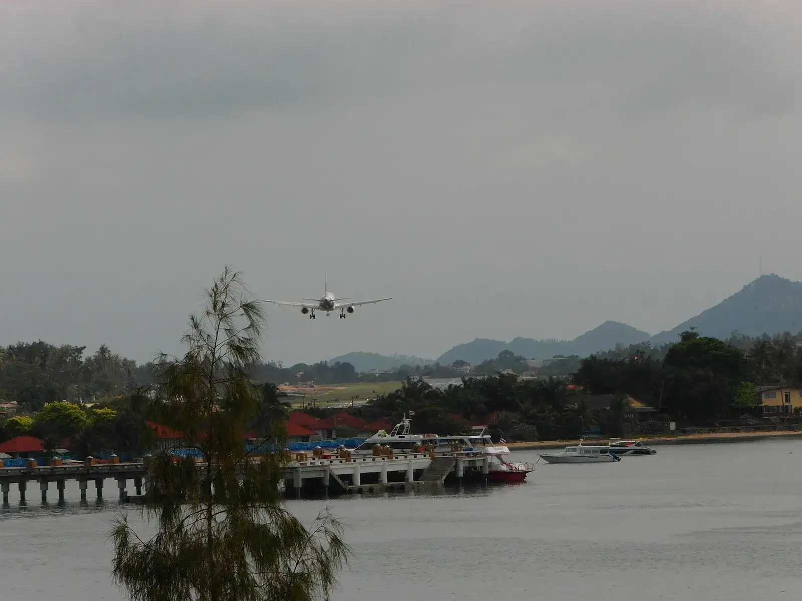 Big Buddha pier area on Koh Samui with boats and a landing plane