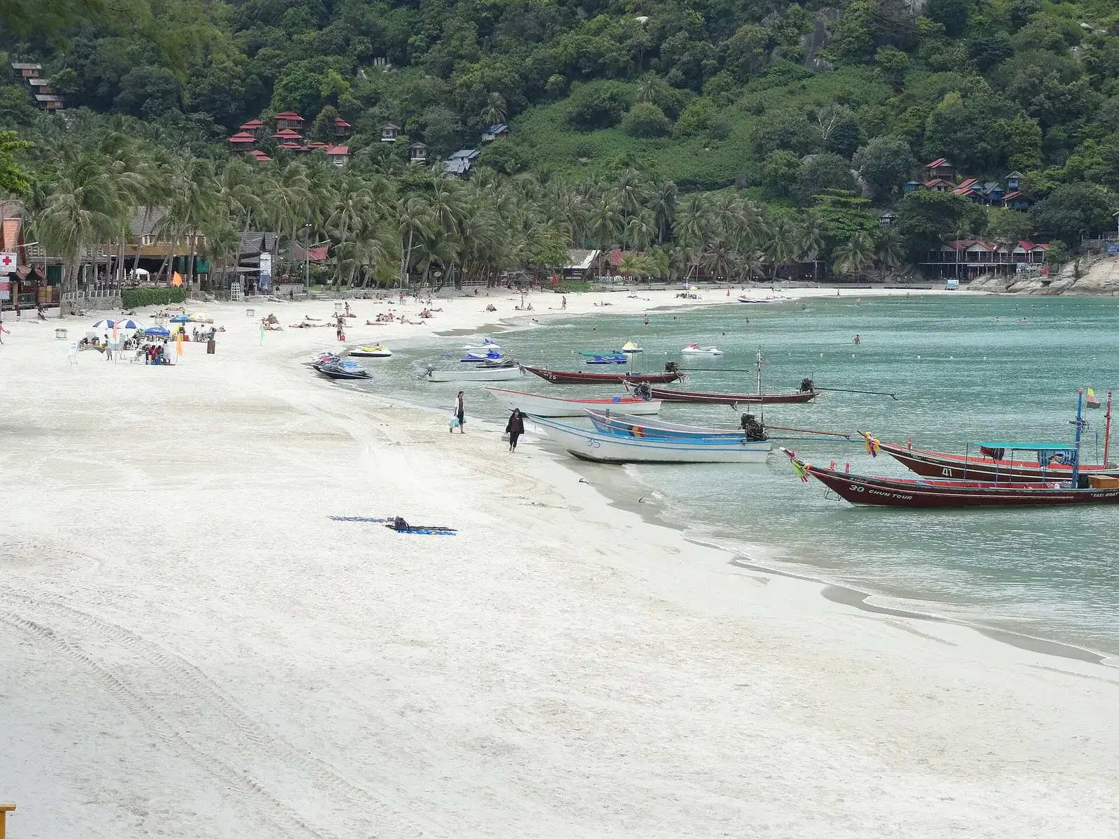 Haad Rin Sunrise Beach with longtail boats moored along the white sand