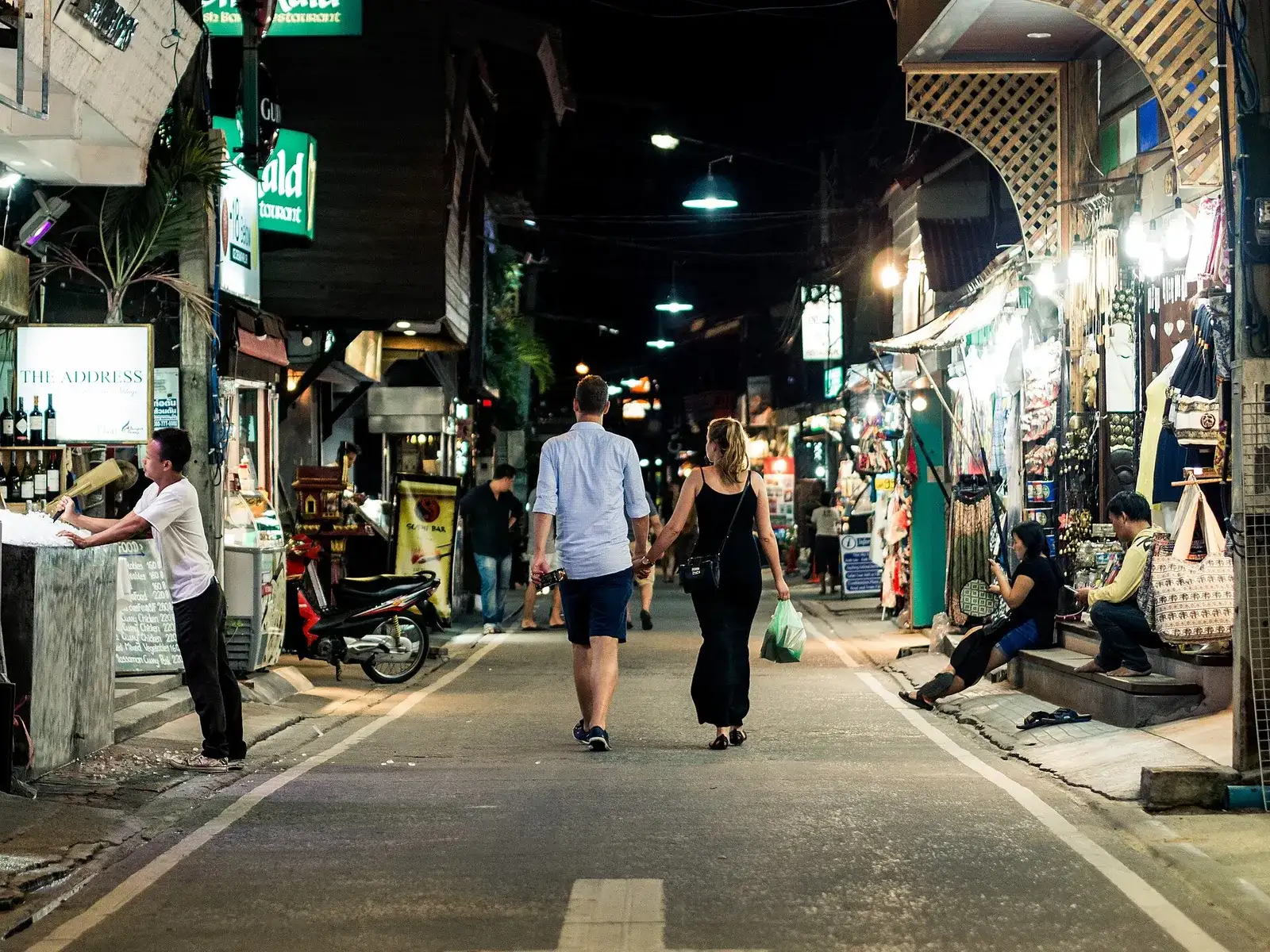 Evening street with small shops and strolling visitors on Koh Samui