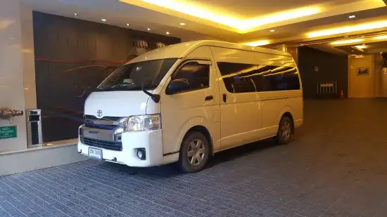 White passenger minivan parked at a hotel entrance driveway